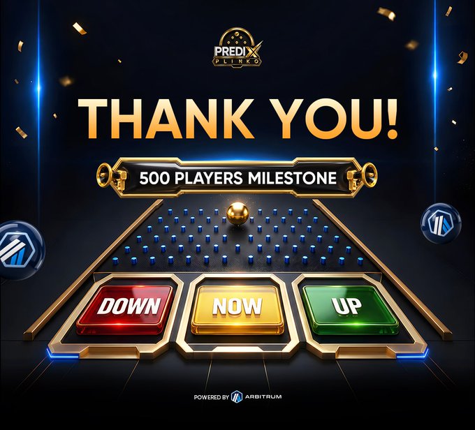 A celebratory promotional graphic from PrediX Plinko displays a large gold "THANK YOU!" banner with a subheading announcing a "500 PLAYERS MILESTONE," set against a dark background with confetti and blue spotlights. Below the text is a stylized Plinko board featuring blue pegs and a gold ball, ending in three colored outcome slots labeled "DOWN" (red), "NOW" (gold), and "UP" (green), while the PrediX Plinko logo sits at the top and an "ARBITRUM" badge appears at the bottom.