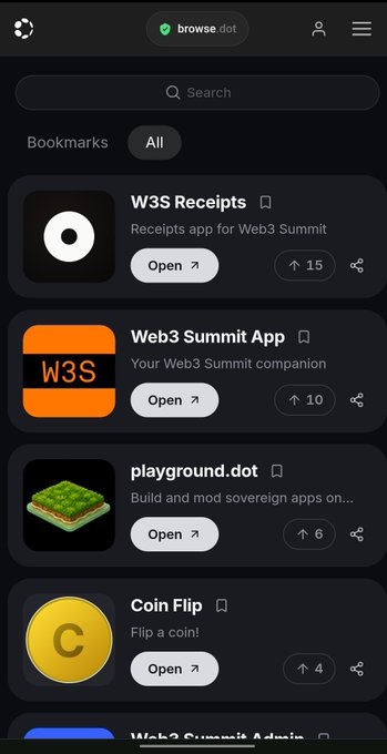 The image shows a cell phone screen displaying various app icons, including one for "Polkadot Web". The focus of the image is on this particular app icon, which is located at the top left corner of the screen. The background color of the image is black, and there are no texts or other objects present in the scene.