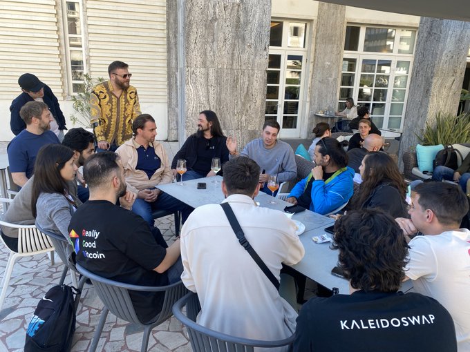 The image shows a group of people sitting around tables outdoors at an event. The attendees are engaged in conversation, with some holding drinks such as wine glasses. There are several chairs placed around the area where the gathering takes place. A potted plant is visible near one of the tables, adding to the outdoor ambiance.

The post about Bitcoin and the @tuscanysummit seems to be related to this gathering in some way. The attendees might be discussing or sharing information about Bitcoin protocols, its development, or even their experiences with it. The event could also serve as a networking opportunity for those involved in the Bitcoin community, allowing them to connect and exchange ideas.