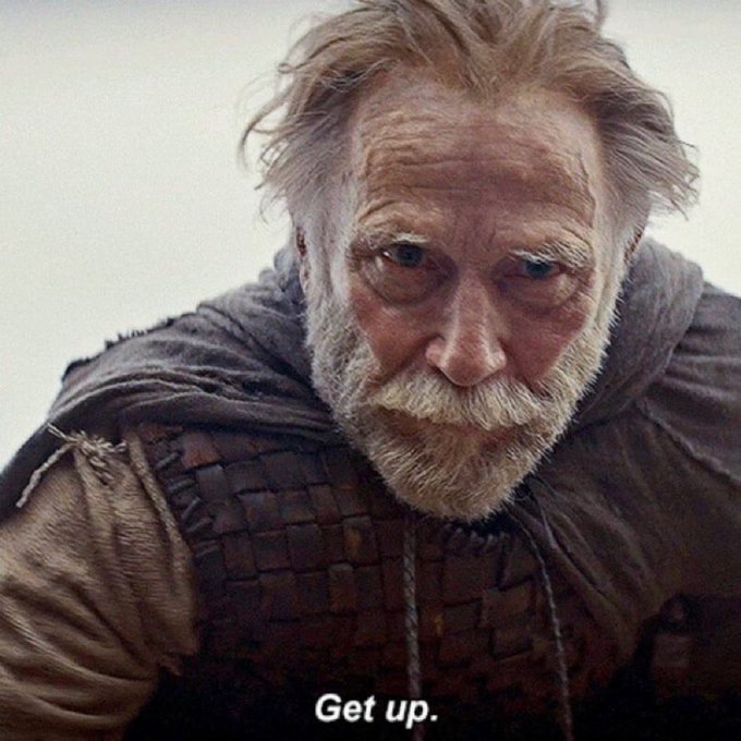 A weathered older man with white hair and beard stares intensely downward with the caption "Get up." displayed at the bottom.