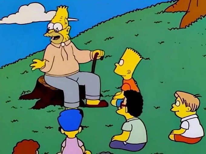 An animated scene showing Grampa Simpson sitting on a tree stump on a grassy hill telling a story to Bart, Milhouse, and other children listening attentively.