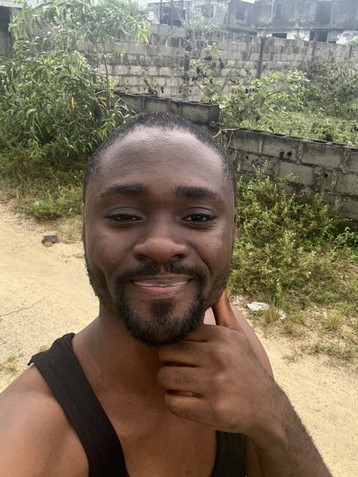 A smiling man in a black tank top gives a thumbs-up gesture outdoors, with greenery and a concrete wall in the background, conveying the upbeat energy referenced in the post about bullish GameStop sentiment and excitement for Web3LagosCon.