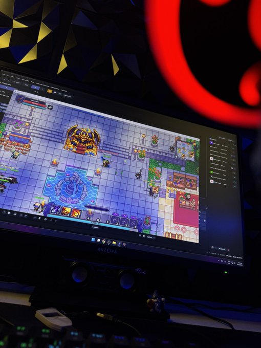 A curved gaming monitor displaying a colorful top-down strategy/RPG game with grid-based levels and characters, with a red circular light glowing in the dark background.