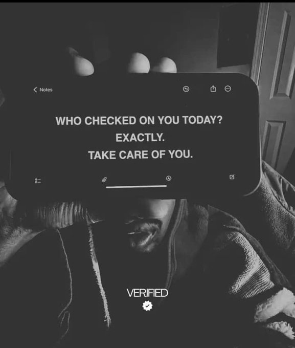The image features a person holding up their phone, which displays a message that reads "Who checked on you today? Exactly. Take care of you." The person's face is partially visible behind the phone screen. The background includes a door and a window, suggesting an indoor setting.