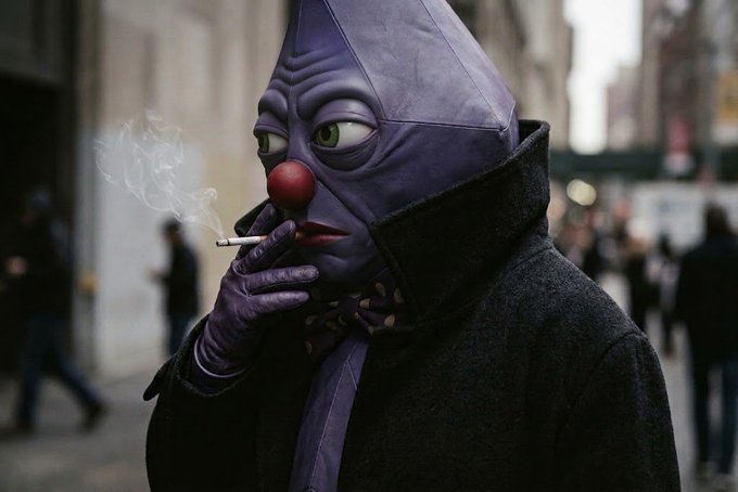 A person in a purple costume with a red clown nose and pointed hood smokes a cigarette on a city street, exhaling a plume of smoke.