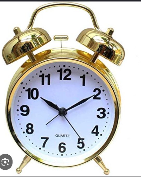 A classic gold twin-bell alarm clock with a white face displaying black numerals and a 'QUARTZ' label.