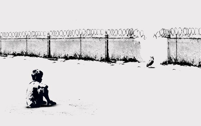 A black and white stencil-style street art piece depicting a young boy sitting on the ground looking across a barbed-wire topped fence at a small dog sitting on the other side.