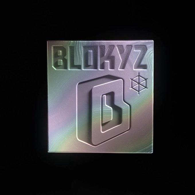 A metallic, iridescent square logo features the embossed text "BLOXYZ" above a stylized "B" emblem and a geometric star symbol.