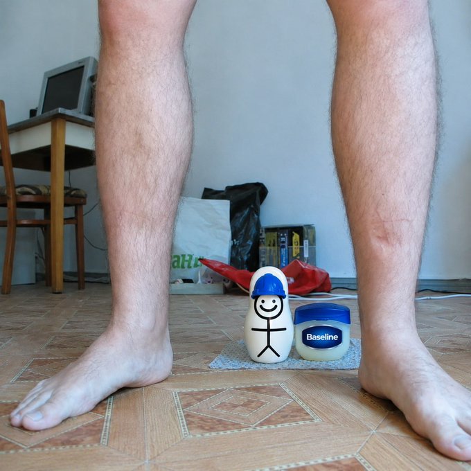 A pair of bare legs frame a whimsical bowling pin figure wearing a blue cap, standing next to a jar labeled "Baseline" on a tiled floor. The image humorously personifies the "o1 testing Base execution layer" by depicting the "Baseline" jar as a pin ready to be knocked down by the towering figure, symbolizing the testing or comparison of execution layers.