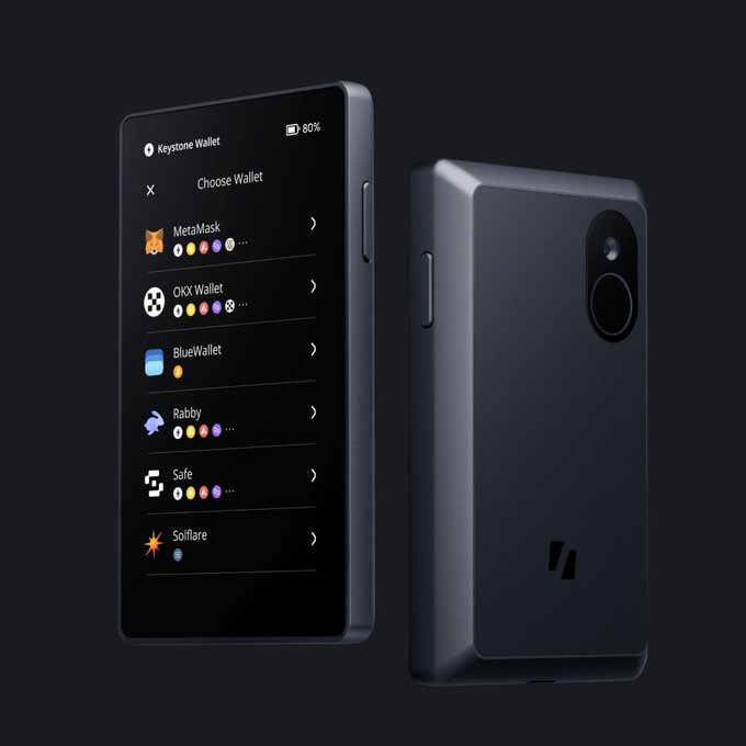 The image shows a black smartphone with an open app that displays various options for choosing a wallet, including Bitcoin and OX wallets. The phone is positioned vertically against a dark background, making its features stand out prominently. The text "Zodl + Keystone" suggests that this is a product from the Zodl brand, which might be related to the wallet feature displayed on the screen.