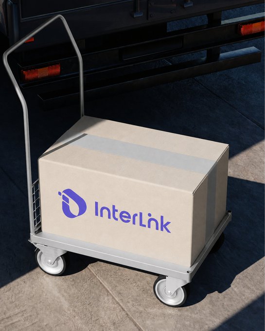 A cardboard box branded "InterLink" sits on a metal delivery hand truck next to a truck's rear bumper, symbolizing an incoming shipment for the company.