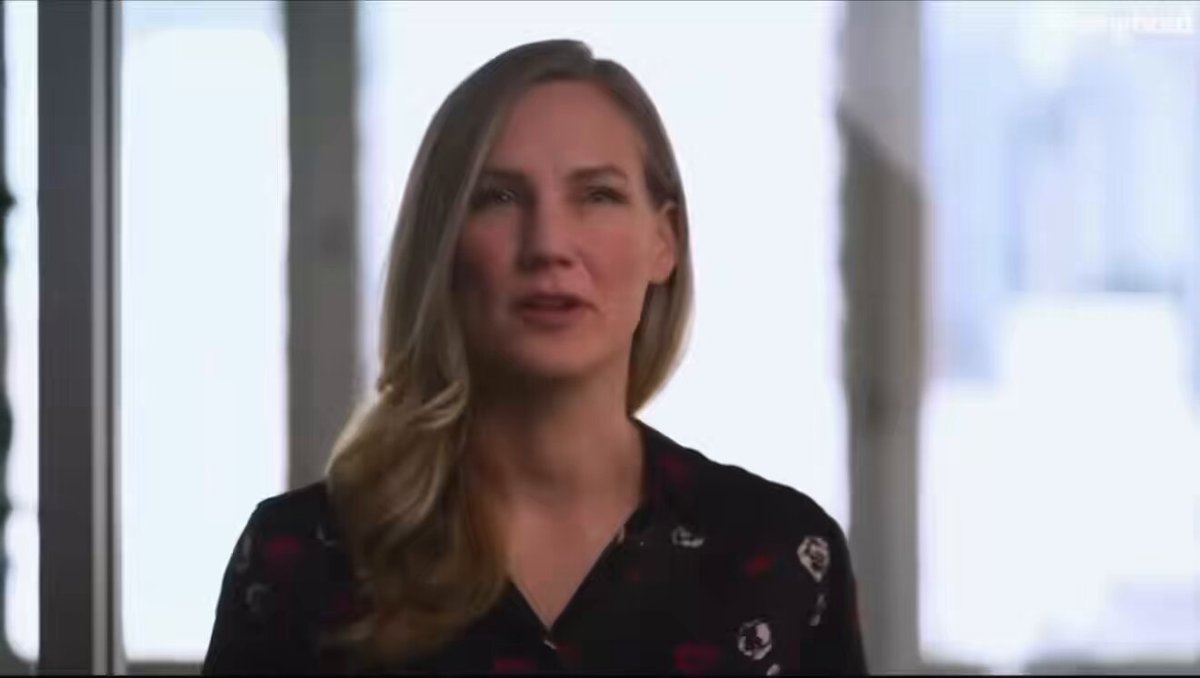 The image features a woman with blonde hair wearing a black shirt, standing against a white background. She appears to be looking directly at the camera while talking. The caption of the image reads "Stronghold let them tell you themselves lmfao -> $XRP & XLM ARE THE BODY MEMBERS OF THE NEW ISO STANDARD." This statement is related to the content in the image, as it seems that the woman is discussing or promoting a new ISO standard.