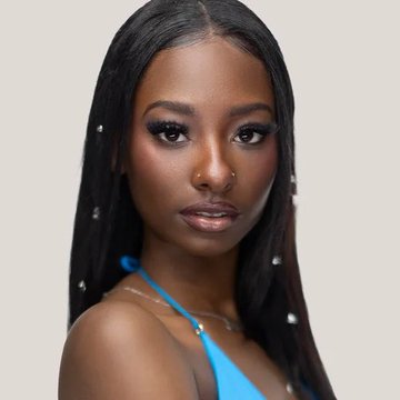A close-up portrait of a young woman with long dark hair, glamorous makeup, and a blue top, shown against a light background. The image accompanies a post about Trinity Tatum's rising odds to win Love Island USA Season 8 on Polymarket.