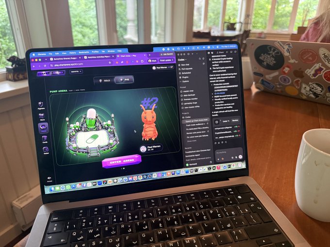 A MacBook on a wooden desk displays a webpage featuring a cartoon ant character on what appears to be Solana's Monkey Kingdom NFT platform, with chat windows visible alongside the 3D arena graphic.