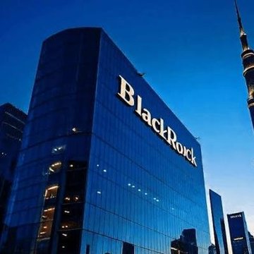 A photograph of a modern glass skyscraper displaying the 'BlackRock' logo in large white letters, set against a clear blue sky with another tall tower visible in the background.