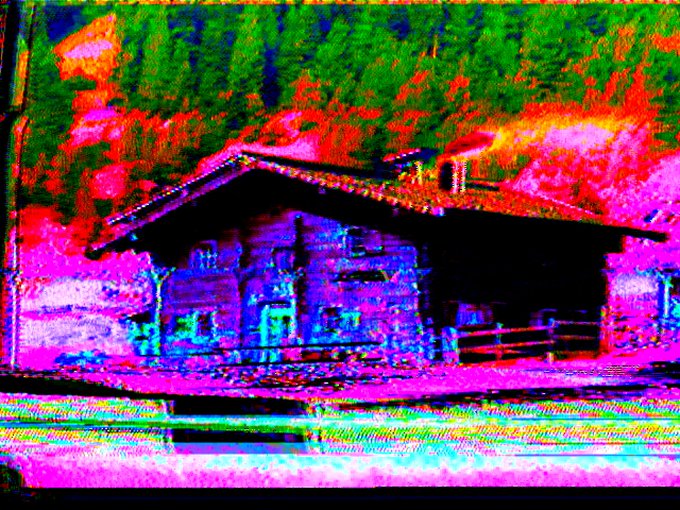 A heavily distorted, glitch-art style image of a wooden cabin with a sloped roof, rendered in vibrant, oversaturated neon colors of pink, green, blue, and red with visible horizontal scan lines.