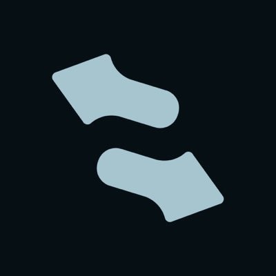 A simple minimalist icon of two stylized grey socks on a dark background.