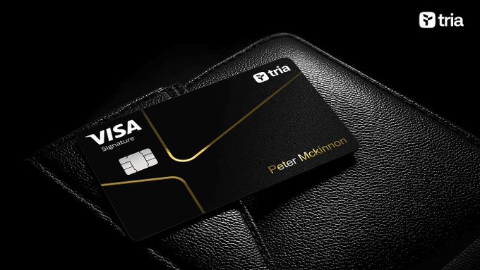 The image shows a black wallet placed on top of a leather purse or briefcase. The wallet has a Visa logo on it, indicating that it's a credit card holder from Visa. The background of the image is dark, which contrasts with the lighter colors of the wallet and purse. The text in the image reads "It's honestly hard going back to normal trading apps after using @useTria for a while. No manual bridging. No juggling gas tokens across multiple chains. You just open the app, trade perps, and move on with your day." This message suggests that the user might be experiencing difficulties in their daily life due to the transition from traditional payment methods like credit cards to newer digital payment platforms or apps.