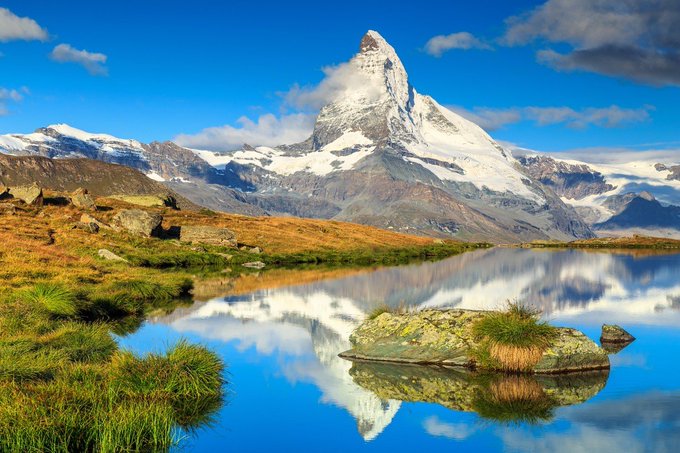 A serene alpine lake reflects the iconic Matterhorn peak beneath a bright blue sky, symbolizing pristine clarity and reflection. Much like blockchain's immutable ledger, the flawless mirror image represents how transactions are transparently recorded and cannot be altered—a perfect natural metaphor for trust through verification.
