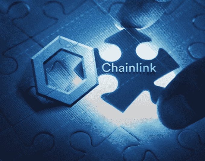 A blue-tinted image showing a hand placing a puzzle piece with the Chainlink logo next to a hexagonal token piece, symbolizing a partnership or integration with Chainlink (LINK).