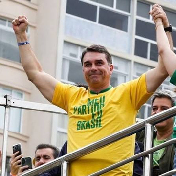 A smiling man in a yellow Brazilian football jersey raises his arms triumphantly amid a crowd, with the text "MEU PARTIDO É BRASIL" visible on his shirt, celebrating Flávio's surging lead over Lula in the Polymarket prediction. The celebratory pose captures the "stunning turnaround" referenced in the post, visually reflecting Flávio's rising momentum in the polls.