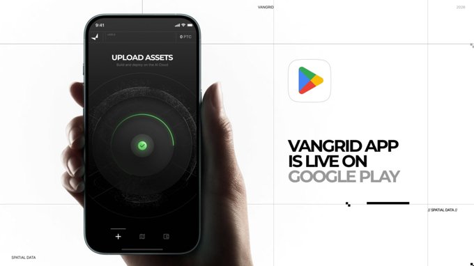 A promotional image for the VANGRID APP showing a smartphone displaying an 'UPLOAD ASSETS' interface with a green circular indicator, alongside the Google Play logo and text announcing 'VANGRID APP IS LIVE ON GOOGLE PLAY.'