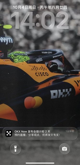 An iPhone lock screen shows the time '14:02' and date '10月4日周日' (Sunday, October 4th), featuring a Formula 1 race car and a notification about an upcoming OKX live stream.