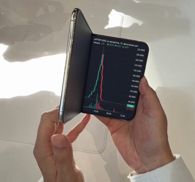 A person's hands hold open a foldable smartphone displaying a stock chart for the ticker "$LAPTOP/USDC" on Aerodrome, showing a massive vertical spike in price with values ranging from around 40 to 320. The image humorously illustrates the post's claim of investing in the "$LAPTOP" token alongside purchasing the "iPhone Duo" foldable device.