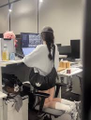 The image shows a person in a white shirt standing in an office workspace with a computer monitor and a bottle of what appears to be Fairy dish soap visible on the desk. The photo seems unrelated to the post about Polymarket trading bots, possibly serving as a casual background image showing a typical work-from-home setup where someone might be developing or testing trading tools using Claude Code.