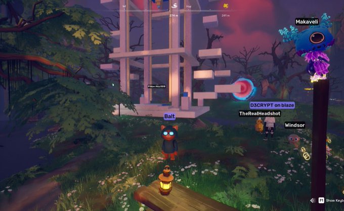 A screenshot from a video game showing a character named 'Balt' in a red devil costume standing in a grassy forest area near a structure, with other player names like 'Makaveli,' 'TheRealHeadshot,' and 'Windsor' visible.