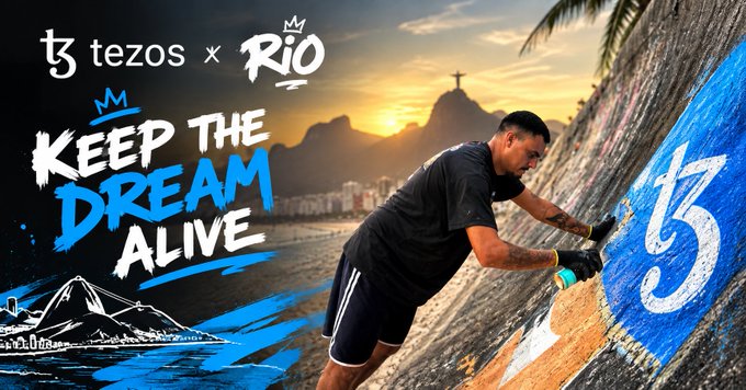 A promotional graphic for 'tezos x RIO' features the text 'KEEP THE DREAM ALIVE' alongside a man painting graffiti on a wall with the Rio de Janeiro skyline and Christ the Redeemer statue in the background.