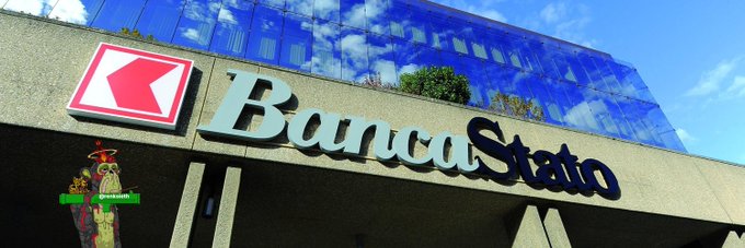 The BancaStato bank building features its prominent logo with a red key emblem and the bank's name displayed in bold lettering above the entrance. This Swiss bank is shown in connection with its recent integration of Litecoin ($LTC) into its traditional banking app, allowing customers to buy, sell, and hold the cryptocurrency alongside their regular bank accounts.