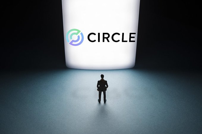 A tiny silhouetted figure stands facing a large illuminated "CIRCLE" logo, symbolizing the stablecoin issuer confronting mounting challenges as the company faces a 17.55% stock drop amid competition from a new stablecoin project backed by major industry players like Visa, Mastercard, and Coinbase.