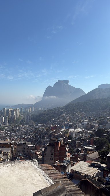 A scenic view of a densely populated city with a prominent mountain peak in the background under a clear blue sky.