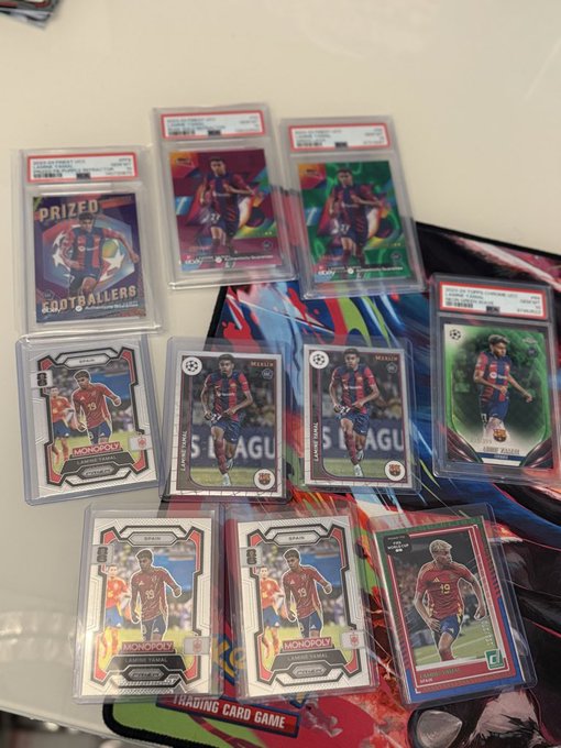 A collection of graded and ungraded sports trading cards featuring soccer player Sergio Agüero in various jerseys, along with a card labeled 'PRIZED FOOTBALLERS' and 'COLD DRINKS' visible in a scene.