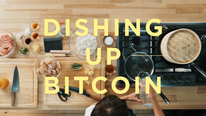 An overhead shot of a kitchen counter with various ingredients and cooking utensils, overlaid with the large yellow text 'DISHING UP BITCOIN'.