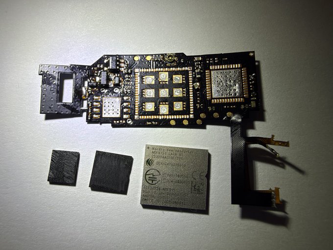 A disassembled Ledger hardware wallet reveals its internal circuit board alongside a Nordic Semiconductor LTE module (marked "nRF9160"), two shielding pads, and a ribbon cable—visual evidence of the sophisticated hardware modifications behind the recent Ledger supply chain attack.