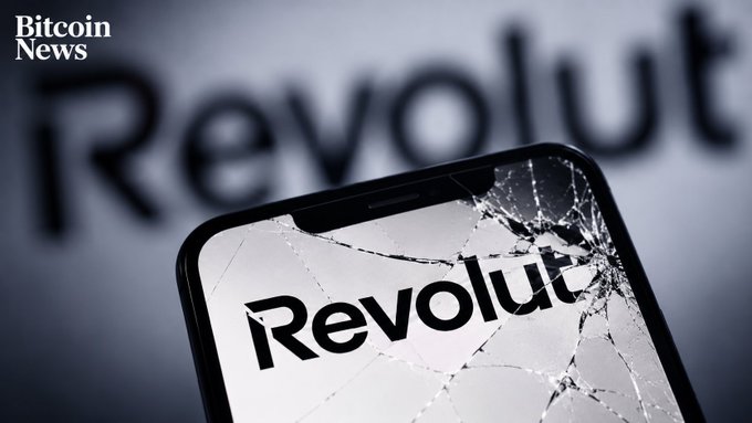 A cracked smartphone screen displays the "Revolut" logo, with the brand name also visible in the blurred background and a "Bitcoin News" watermark in the corner, visually symbolizing the breach of customer data—including Bitcoin transaction histories—that the fintech company reportedly disclosed in response to a fraudulent government request.