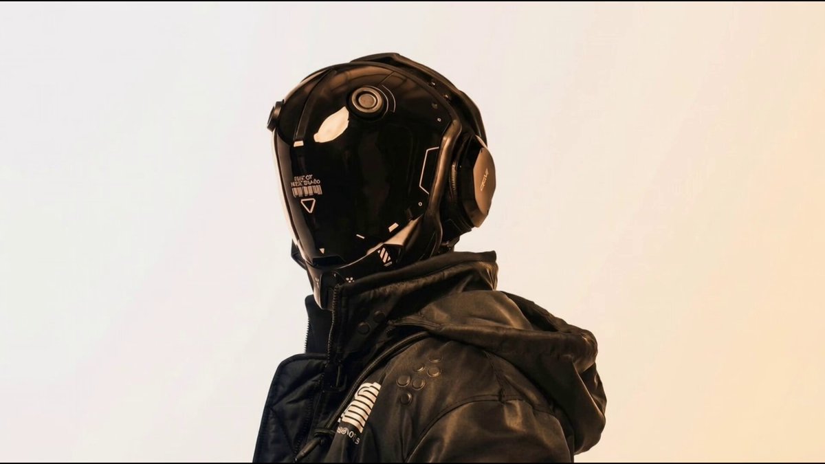 The image features a person wearing a black helmet with goggles, standing against a white background. The caption above the photo reads "One nice thing about AURA is that it can do everything, across all of the best models." This suggests that the person in the image might be an enthusiast for futuristic or science fiction themes and could potentially be interested in exploring the capabilities of the futuristic helmet they are wearing.