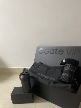 A black 'Gate VIP' promotional package bundle containing branded items like a thermos, gloves, cap, bag, and clothing items.