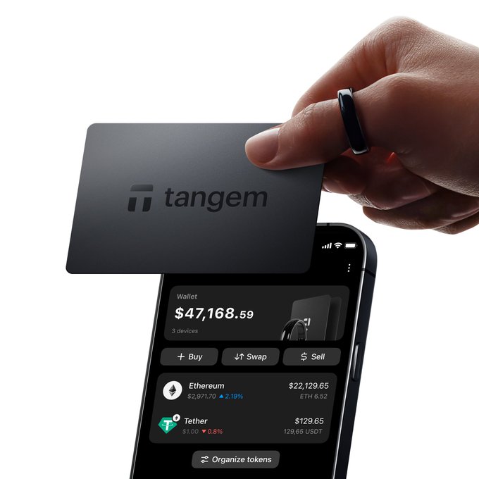 In the image, a person's hand is holding a black credit card over a smartphone screen displaying information about an etherium wallet. The wallet allows users to store their digital assets securely without the need for a traditional bank account or physical cash. It can be easily activated with a simple tap on the phone and provides various features such as transaction history, balance checks, and the ability to buy Etherium tokens. This wallet is designed to keep valuable digital assets close at hand while offering convenience and security.