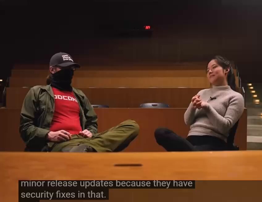 The image shows a man wearing a red shirt and a woman sitting next to him with her hands folded on her lap. The text "April 2025, the run-up to the merge of the OP_RETURN uncap." indicates that this is an article from Bitcoin Magazine about the maintainer who closed six weeks later. The post also mentions that the interviewer offered an apology for any criticism directed towards them.