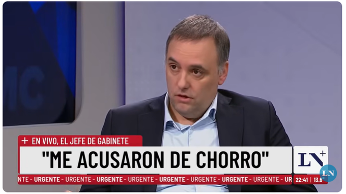 The image shows a man sitting at a desk with a TV screen behind him. The TV screen displays a news segment about Bitcoin transactions, which includes an interview with someone named Adorni who claimed to have sold Bitcoin positions outside of exchanges. The man in the image appears to be a news reporter or anchor discussing this topic on television.