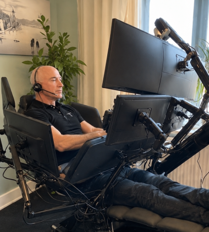 A man wearing headphones reclines in an elaborate multi-monitor trading chair setup, fully geared up to watch financial markets. The image humorously pairs with the caption mocking a small $83 position as if it could significantly impact the trader's life ahead of the FOMC decision.
