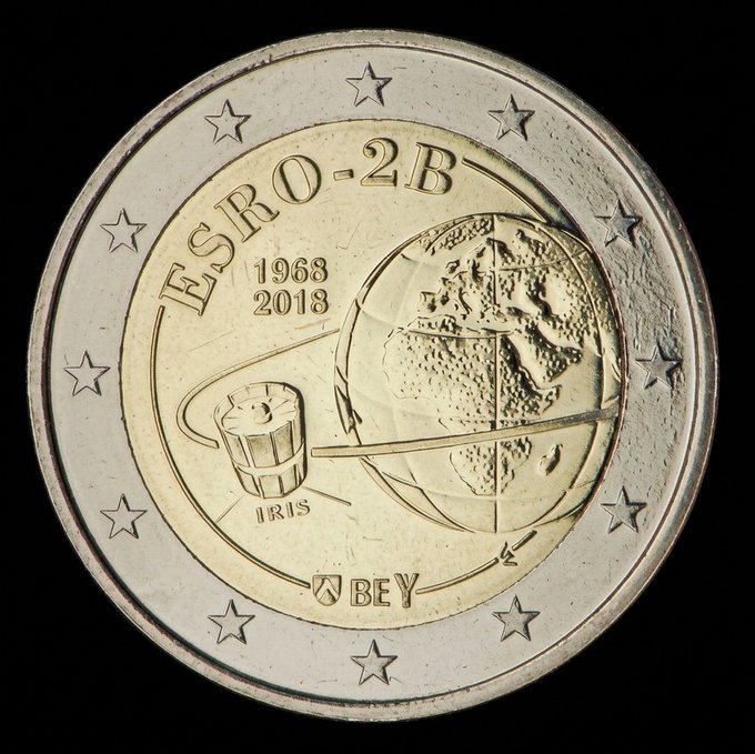 The image features a coin with a globe design, which has the words "Estro" and "2B" written on it. The coin also includes stars around its edges, adding an artistic touch. The text "GTD Phase is live!!! Let' s send it into space! opensea.io/collection/2-c" suggests that this coin might be related to a space exploration project or event.