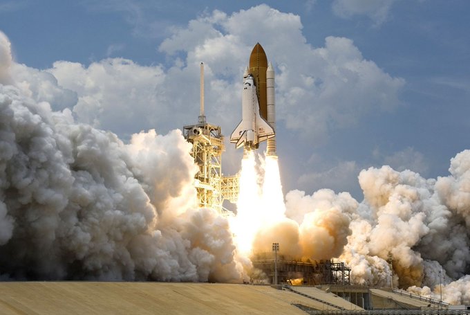 A space shuttle launches from a pad amid massive plumes of smoke and bright flames. The image symbolizes a dramatic "launch" and explosive momentum, mirroring the rapid rise of the CASHCAT memecoin on Robinhood Chain before its sudden collapse.