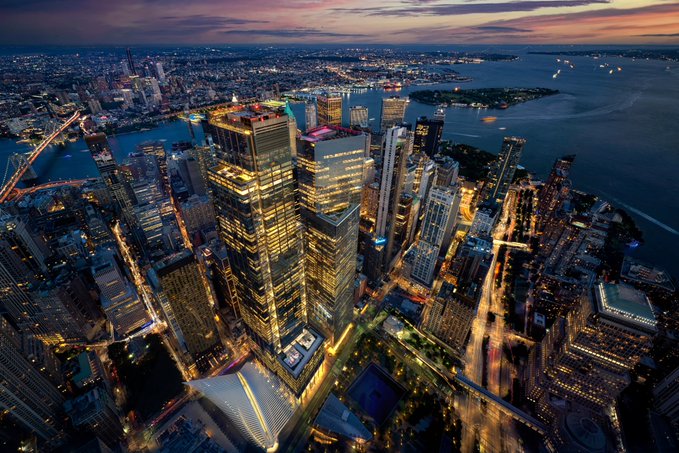 An aerial cityscape at dusk showing illuminated skyscrapers and water, with text overlay reading "Hong Kong Wallpaper 4K".