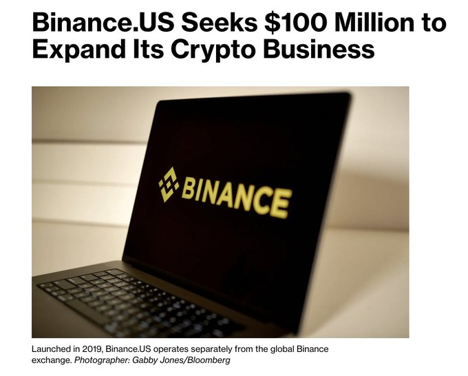 A news headline reading 'Binance.US Seeks $100 Million to Expand Its Crypto Business' featuring a photo of a laptop displaying the yellow Binance logo, with a caption noting the exchange launched in 2019 and operates separately from global Binance.