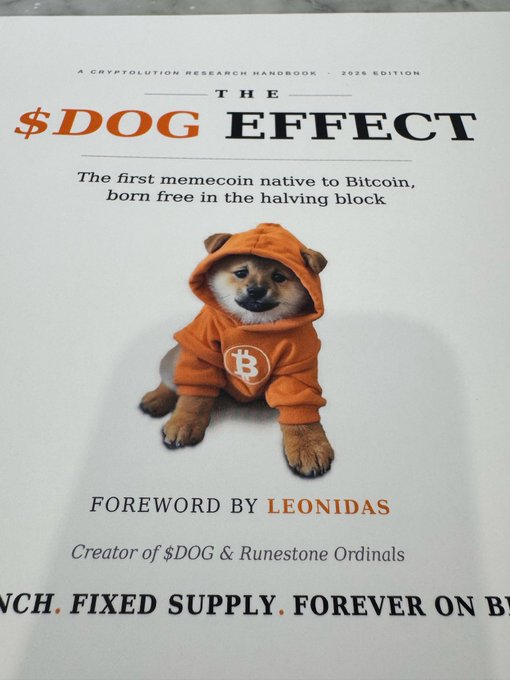 A book cover titled 'THE $DOG EFFECT' described as 'A CRYPTOLUTION RESEARCH HANDBOOK • 2026 EDITION' featuring a Shiba Inu dog wearing an orange hoodie with a Bitcoin logo, with a foreword by Leonidas, creator of $DOG & Runestone Ordinals.