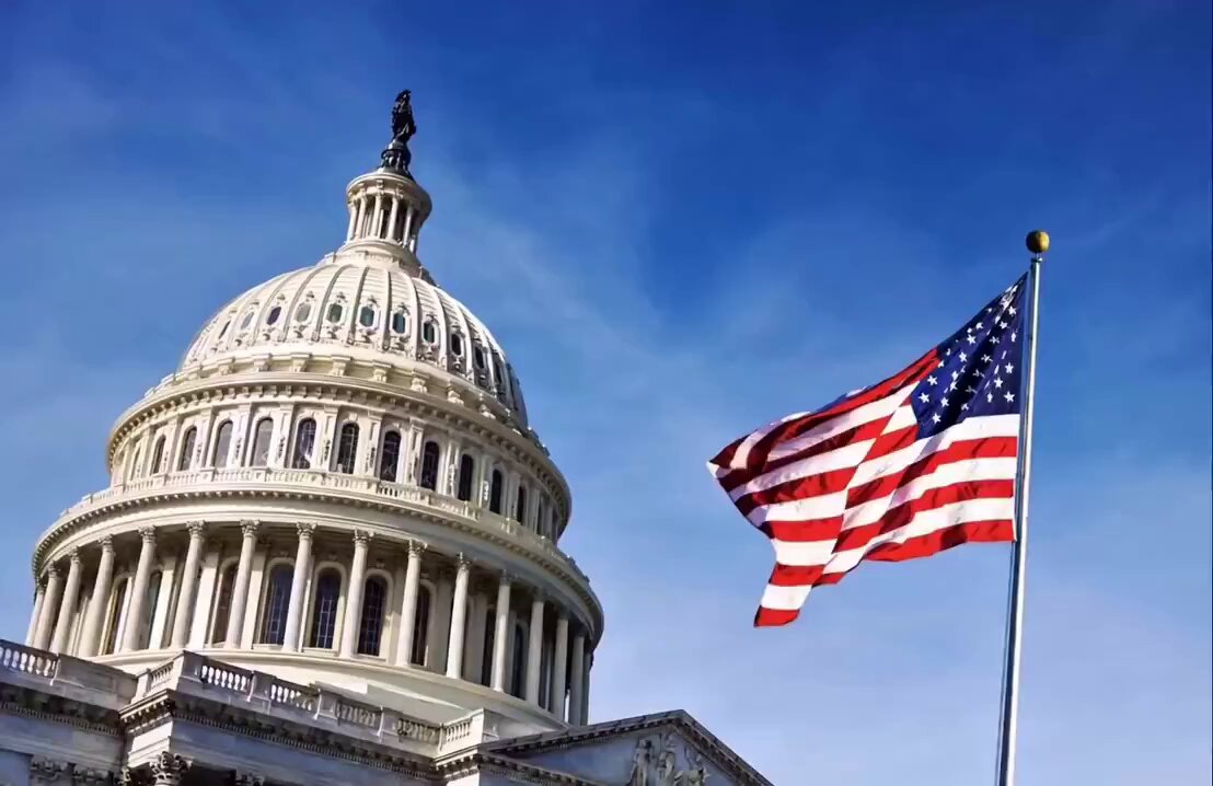 The image features a large white building with an American flag flying above it, which appears to be the U.S. Capitol Building. Below the Capitol Building, there are two flags - one representing the United States of America (the American flag) and another representing Ripple Cryptocurrency. The text in the image reads "XRP & CRYPTO TAX UPDATE House Republicans have introduced seven new tax bills focused on XRP and the broader cryptocurrency market ahead of next week's congressional hearing".
